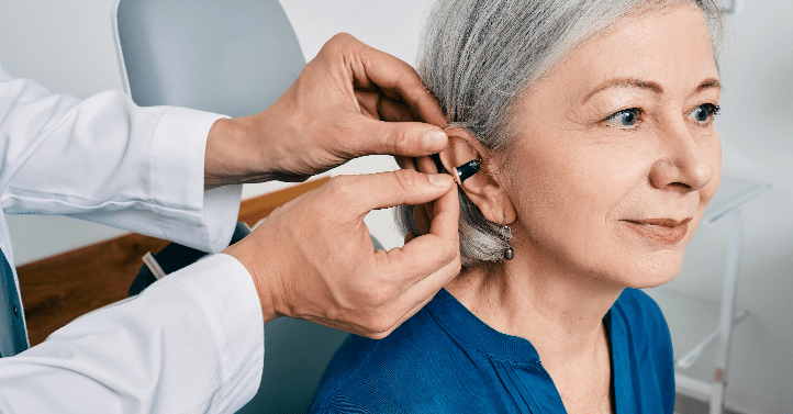 Woman getting hearing aid fitted by audiologist at New River Valley Hearing in Radford, VA