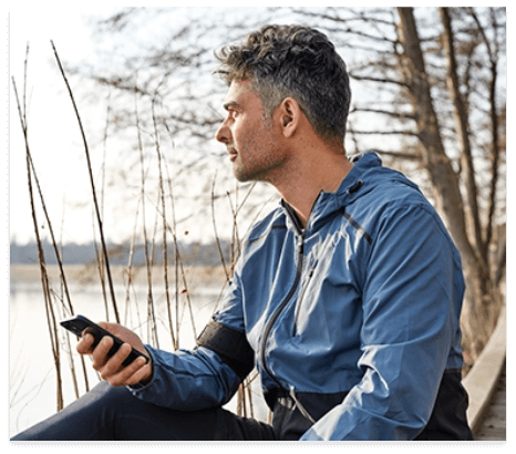 man sitting outdoors with oticon hearing aids in